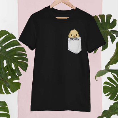 Schwarzes, modernes T-Shirt mit einem liebevoll gezeichneten Küken, das aus einer aufgedruckten Brusttasche mit 'Tierschutz' hervorschaut